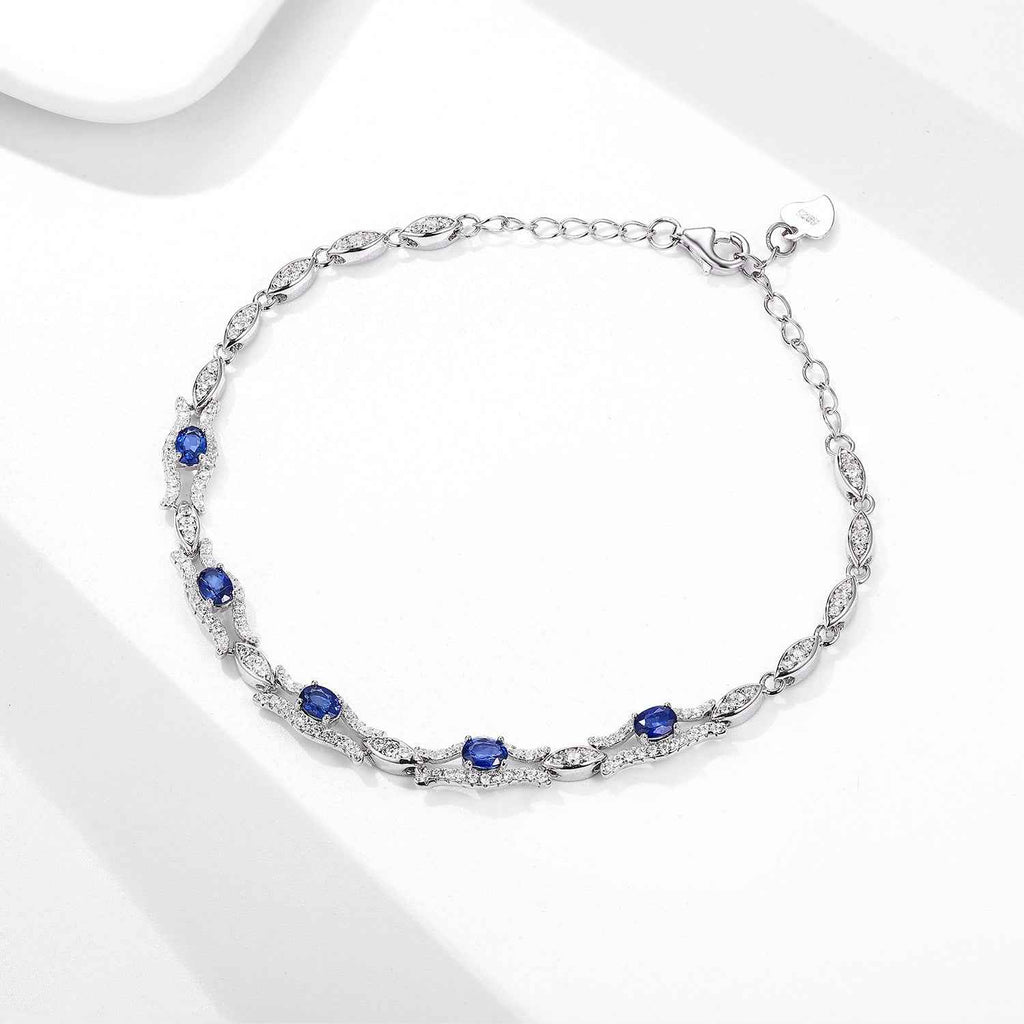 Sapphire tennis bracelet in silver tone with blue round gemstones and clear accents
