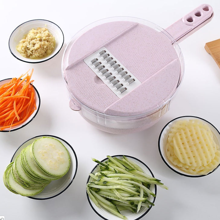 Pink mandoline slicer with round grating drum and side handle, blade insert shown