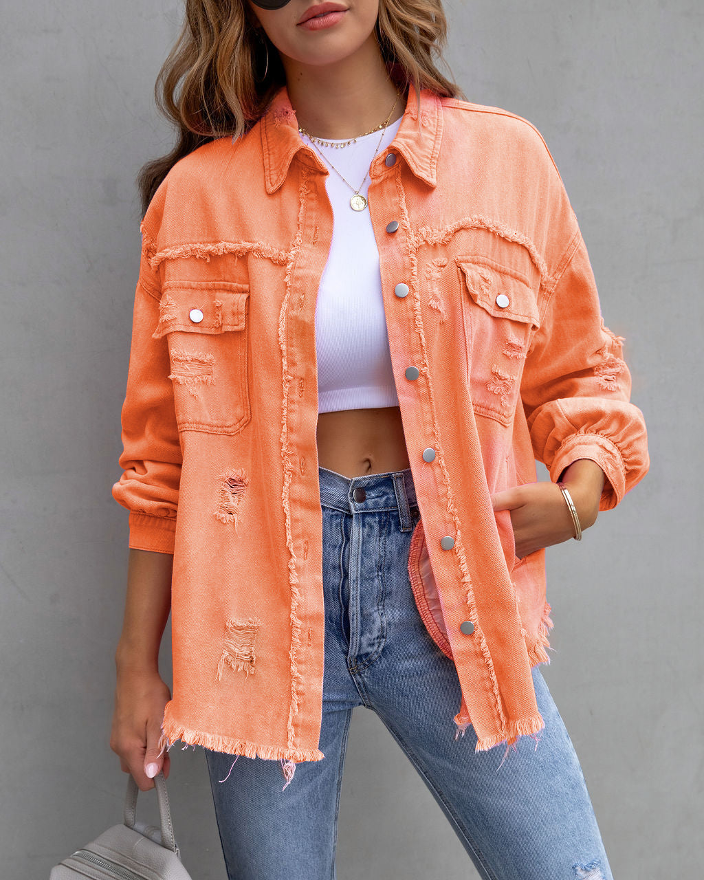 Women’s ripped denim shirt jacket in orange, with button front and flap chest pockets