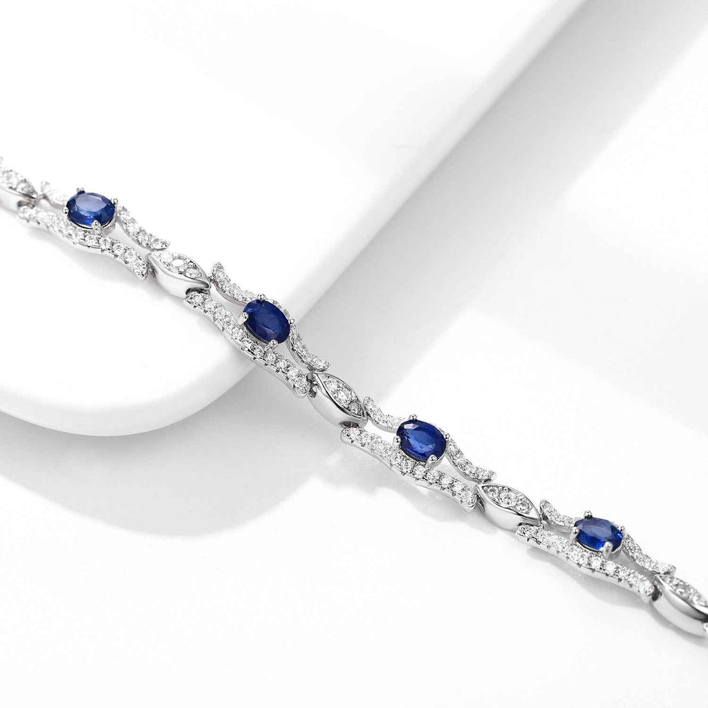 Silver sapphire tennis bracelet close-up with blue oval center stones and sparkle links