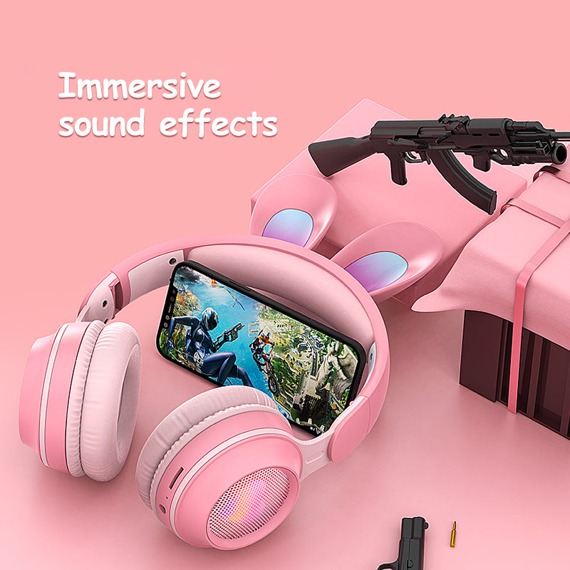 Pink rabbit-ear wireless headphones with cushioned over-ear cups and glowing speaker grill
