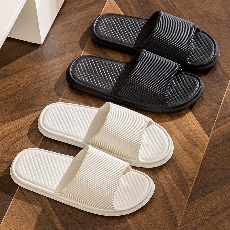 Black and white slide slippers with textured footbeds and striped straps