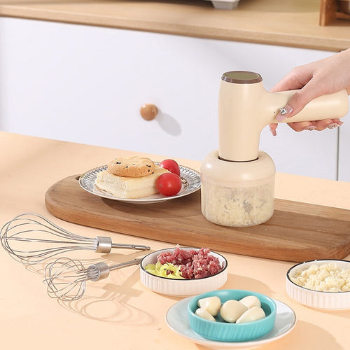 Beige handheld electric chopper on countertop with clear chopper cup
