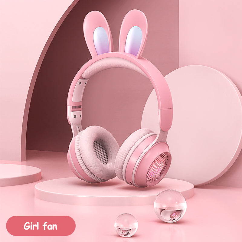 Pink rabbit-ear wireless headphones with padded over-ear cups and glowing speaker grill